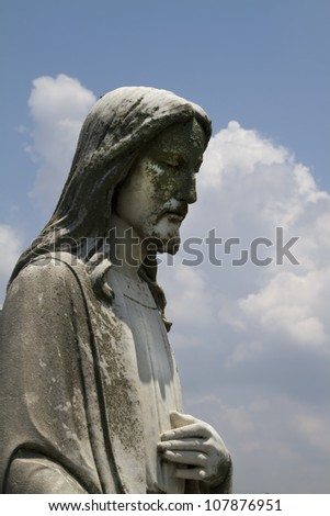 Lord Jesus Christ Cemetery Statue with cloudy blue sky/The Lord Jesus Christ Cement Statue/Lord Jesus Christ Cemetery Statue with cloudy blue sky