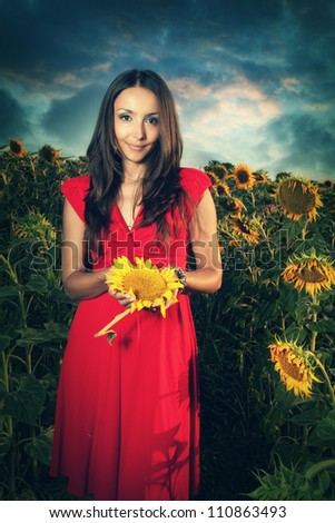 Girl in red dress at sunflowers field
