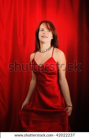 Half body portrait of attractive young woman in red party dress.