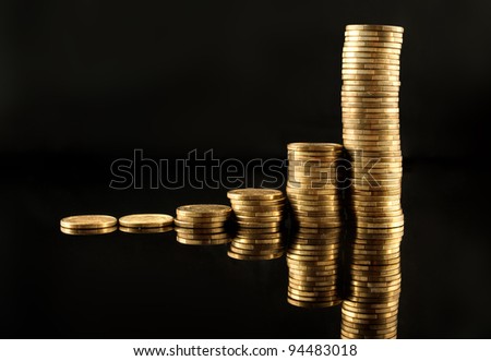 Business graph made out of golden coins over a black background with reflection