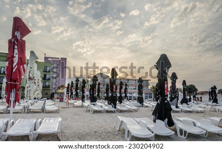MAMAIA BEACH, ROMANIA - SEPTEMBER 4, 2014. The sea side at sunset with umbrellas, sand and sun beds.