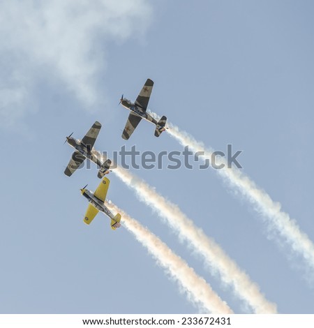 BUCHAREST, ROMANIA - OCTOBER 4, 2014. Aerobatic airplane pilots training in the sky of the city. Colored airplane with trace smoke.