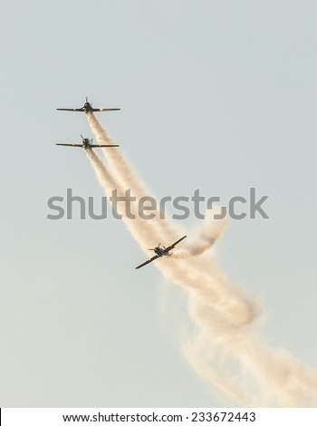BUCHAREST, ROMANIA - OCTOBER 4, 2014. Aerobatic airplane pilots training in the sky of the city. Colored airplane with trace smoke.
