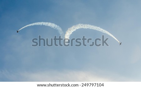 BUCHAREST, ROMANIA - OCTOBER 4, 2014. Aerobatic airplane pilots training in the sky of the city. Colored airplane with trace smoke
