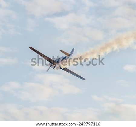 BUCHAREST, ROMANIA - OCTOBER 4, 2014. Aerobatic airplane pilots training in the sky of the city. Colored airplane with trace smoke, heart shape smoke and arrow