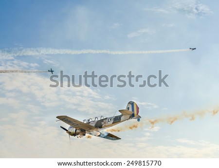 BUCHAREST, ROMANIA - OCTOBER 4, 2014. Aerobatic airplane pilots training in the sky of the city. Colored airplanes with trace smoke
