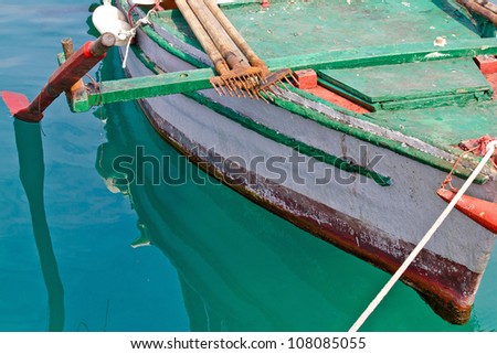 Old wooden colorful fishing boat detail with rusty fish gig
