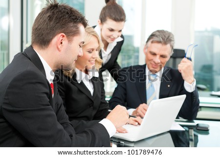 Business people - team meeting in an office with laptop, the boss with his employees