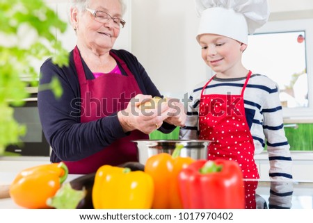 Happy granny cooking together with her grandson