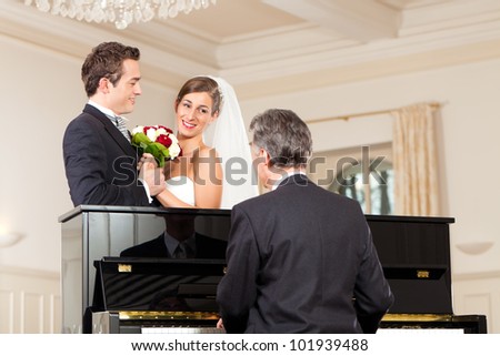 Bridal couple in front of a piano, the pianist is playing a waltz