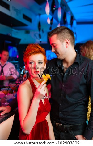 young couple in bar or club drinking cocktails, it might be the first date