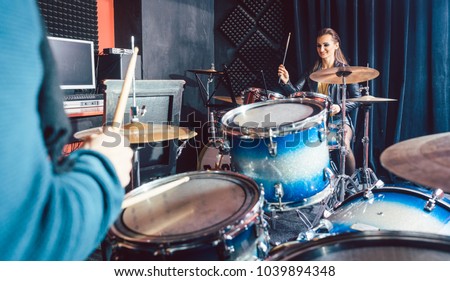 Woman receiving drum lessons from her music teacher in school
