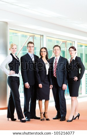 Business - group of businesspeople posing for group photo in office showing thumbs up