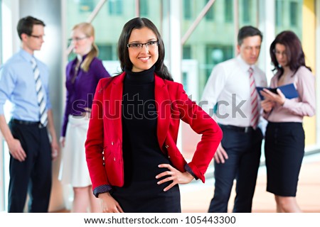 Business people or team in office, a woman is looking to the viewer