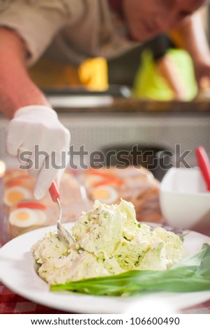 Working in a butchers shop - a shop assistant with curd cheese