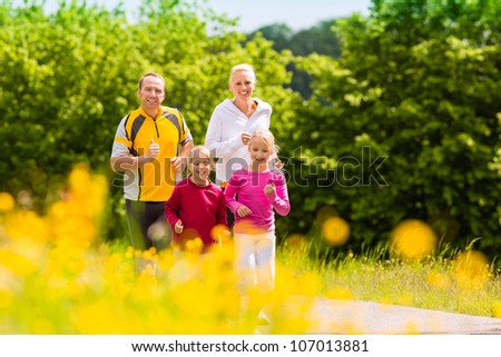 Family jogging for sport outdoors with the kids on summer day