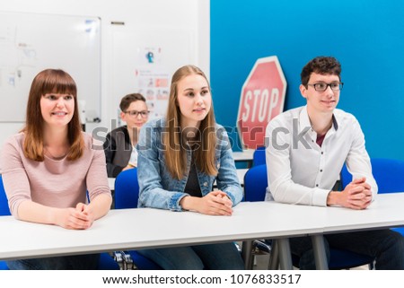Students in driving lessons listening attentively sitting on benches