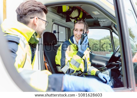 Paramedics in ambulance in radio contact with headquarters discussion deployment