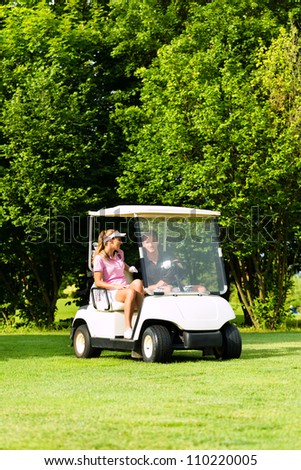 Young sportive couple playing golf on a golf course, they driving with golf cart