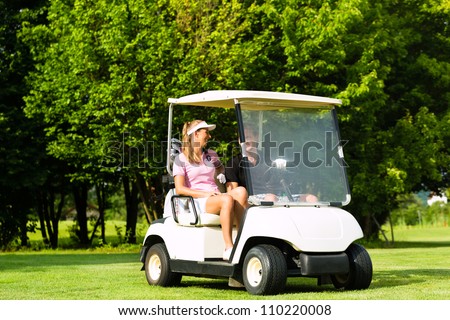 Young sportive couple playing golf on a golf course, they driving with golf cart