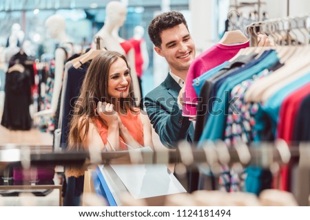Happy couple shopping for fashion items in high end boutique