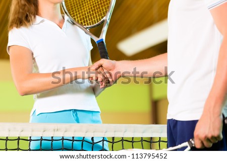 People, woman and man, only upper body with racket, playing tennis giving handshake after match