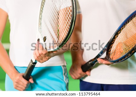 Women, only upper body with racket, playing tennis indoors in court