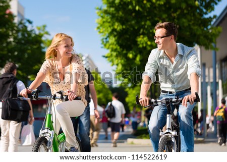 Couple - man and woman - riding their bikes or bicycles in their free time and having fun on a sunny summer day