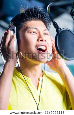 Asian professional musician recording new song or album CD in studio