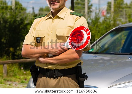 Police - policeman or cop in uniform stop car in traffic control