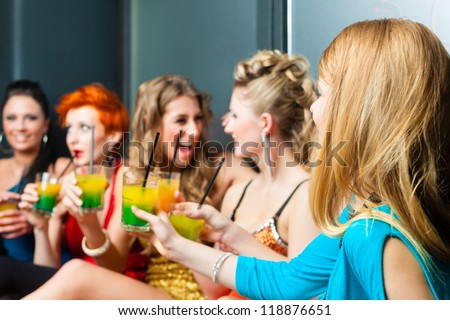 Women or models in club or disco drinking cocktails having fun