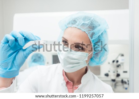 Woman scientist showing her newest biotech experiment in lab petri dish