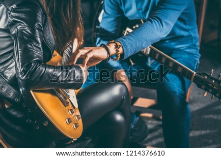 Guitar music teacher helping his student to play, closeup on the hands