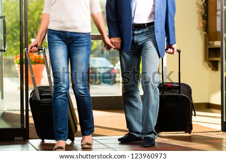 Senior man and woman - married couple - arriving at Hotel with their luggage
