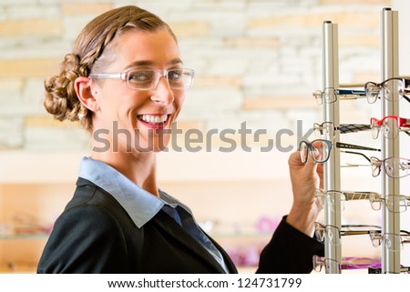 Young woman at optician with glasses, she might be customer or salesperson