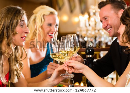 Good friends for dinner or lunch in a fine restaurant, clinking glasses
