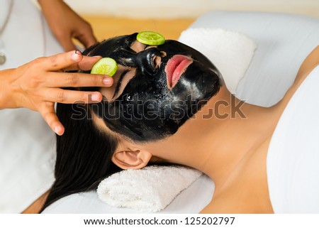Young Asian Woman in a beauty spa getting a treatment with mask to bleach the skin