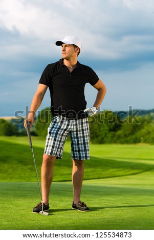 Young sportive man playing golf on a course, he might play a golf tournament