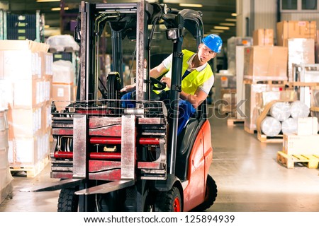 Forklift Driver In Protective Vest Driving Forklift At Warehouse Of Freight Forwarding Company