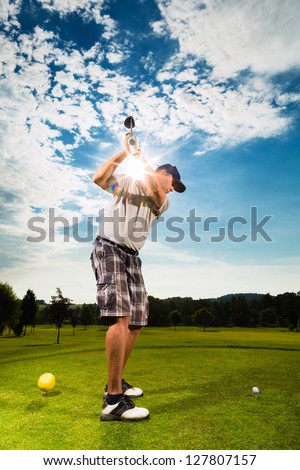 Young golf player on course doing golf swing, he presumably does exercise