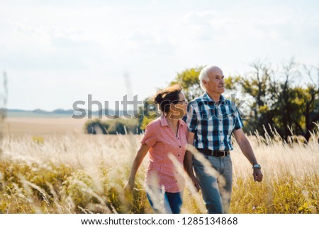 Senior couple walking down a path in nature on a day in late summer