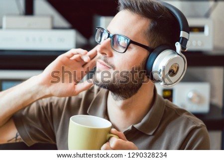 Man drinking coffee and listening to music being carried away by the sound