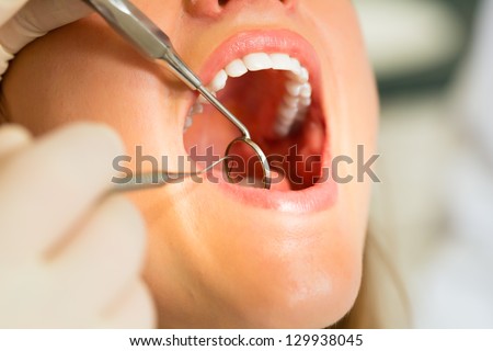 Female patient with dentist in a dental treatment, wearing gloves