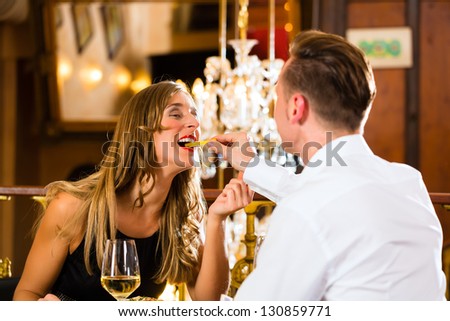http://image.shutterstock.com/display_pic_with_logo/84610/130859771/stock-photo-couple-man-and-woman-in-a-fine-dining-restaurant-they-eat-fast-food-and-fries-a-large-130859771.jpg