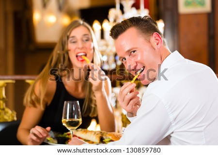 http://image.shutterstock.com/display_pic_with_logo/84610/130859780/stock-photo-couple-man-and-woman-in-a-fine-dining-restaurant-they-eat-fast-food-and-fries-a-large-130859780.jpg