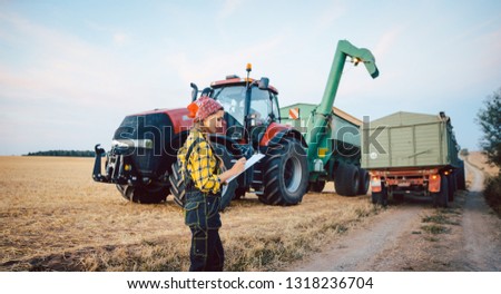 Beautiful farmer crunching numbers of field after a long harvest day