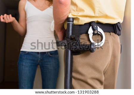 Police officer at front door of home interrogating a woman or witness regarding a police investigation