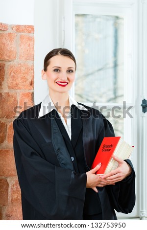 Young female lawyer working in her office reading in a typical law book