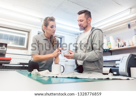 Man and woman discussing which promotional items to use in creative brainstorm
