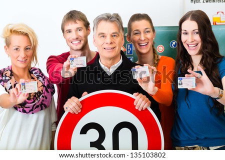 Driving school - driving instructor and student drivers look at a tempo thirty Road sign, in the background are traffic signs